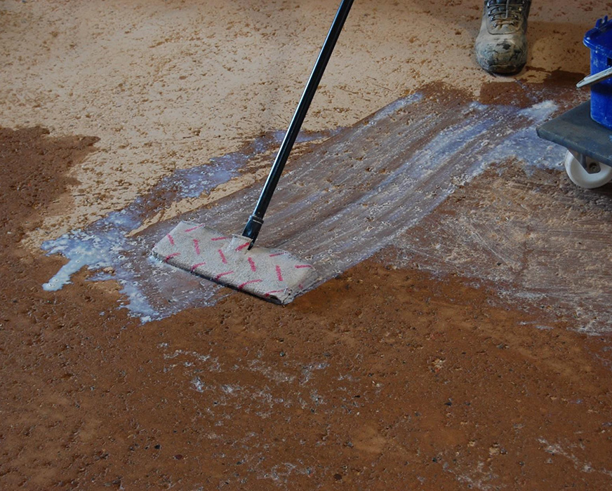 Carnaubawachs-Emulsion satt in den Stampflehmboden einarbeiten